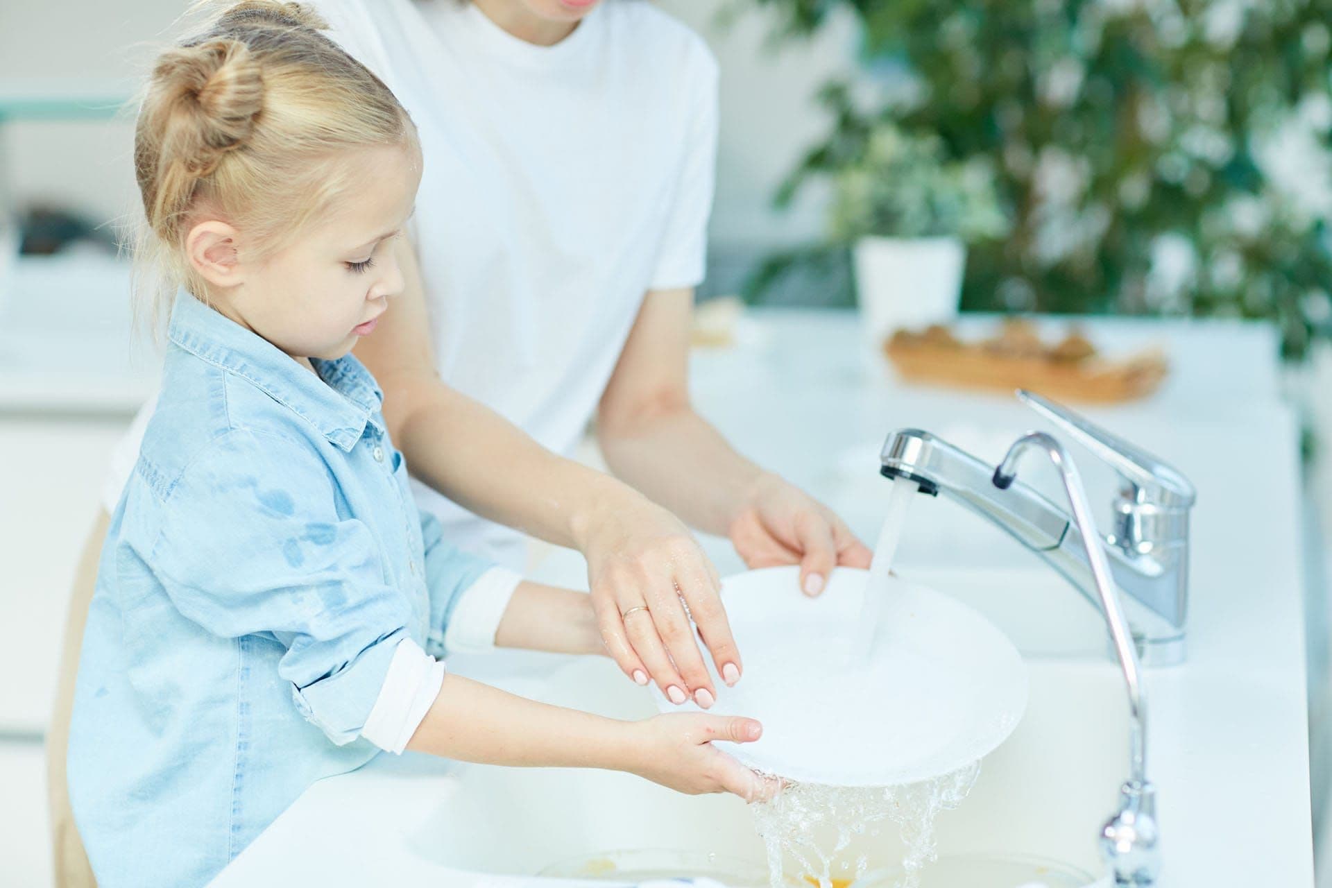 Girl Helping Mother Wash Dishes